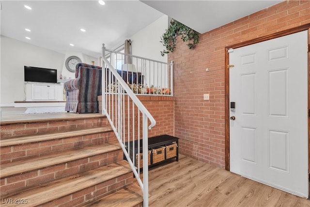 4654 Gabriel Dr, Las Vegas, NV 89121 - staircase with brick wall, wood finished floors, and recessed lighting