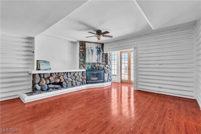 4654 Gabriel Dr, Las Vegas, NV 89121 - unfurnished living room featuring log walls, ceiling fan, a fireplace, wood finished floors, and french doors