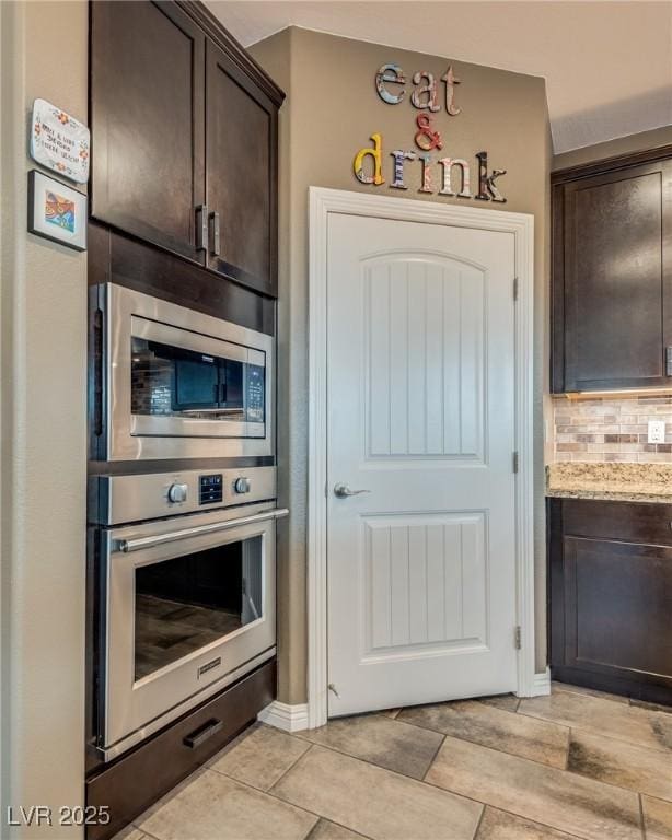 1860 Moonbow Falls St, Henderson, NV 89044 - kitchen featuring stainless steel appliances, dark brown cabinetry, tasteful backsplash, and light stone counters