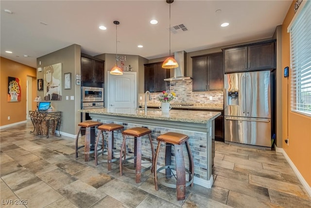 1860 Moonbow Falls St, Henderson, NV 89044 - kitchen featuring stainless steel appliances, wall chimney exhaust hood, decorative backsplash, dark brown cabinetry, and recessed lighting