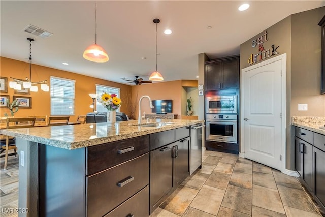 1860 Moonbow Falls St, Henderson, NV 89044 - kitchen featuring stainless steel appliances, decorative light fixtures, a center island with sink, dark brown cabinets, and recessed lighting