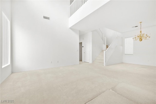8065 Retriever Ave, Las Vegas, NV 89147 - unfurnished living room with carpet floors, stairway, and a chandelier