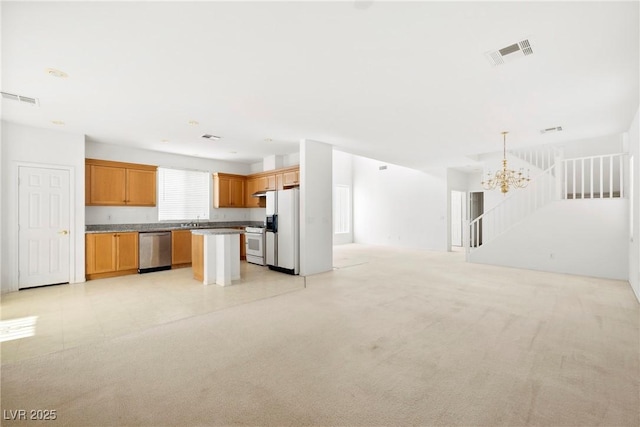 8065 Retriever Ave, Las Vegas, NV 89147 - kitchen with white appliances, open floor plan, a chandelier, brown cabinetry, and a center island