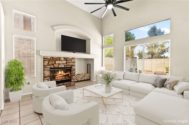 6044 Seneca Springs St, Las Vegas, NV 89130 - living room featuring high vaulted ceiling, light tile patterned floors, a ceiling fan, and a stone fireplace