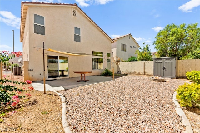 6044 Seneca Springs St, Las Vegas, NV 89130 - back of property featuring stucco siding, a fenced backyard, a patio, and a storage shed