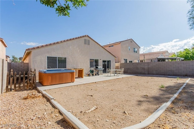 8840 Spinning Wheel Ave, Las Vegas, NV 89143 - rear view of property with a hot tub, a patio area, stucco siding, and a fenced backyard