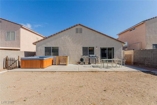 8840 Spinning Wheel Ave, Las Vegas, NV 89143 - back of house featuring a hot tub, a patio area, stucco siding, and a fenced backyard