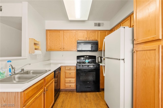 3152 Tarpon Dr Unit 203, Las Vegas, NV 89120 - kitchen featuring black appliances, light wood-style flooring, and light countertops