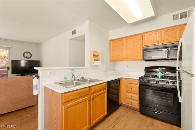 3152 Tarpon Dr Unit 203, Las Vegas, NV 89120 - kitchen with black appliances, light wood finished floors, open floor plan, and a peninsula