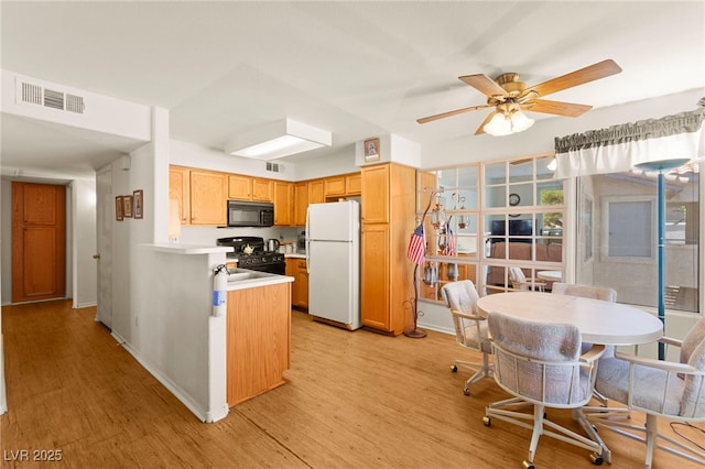 3152 Tarpon Dr Unit 203, Las Vegas, NV 89120 - kitchen featuring black appliances, light countertops, light wood-style floors, ceiling fan, and a peninsula
