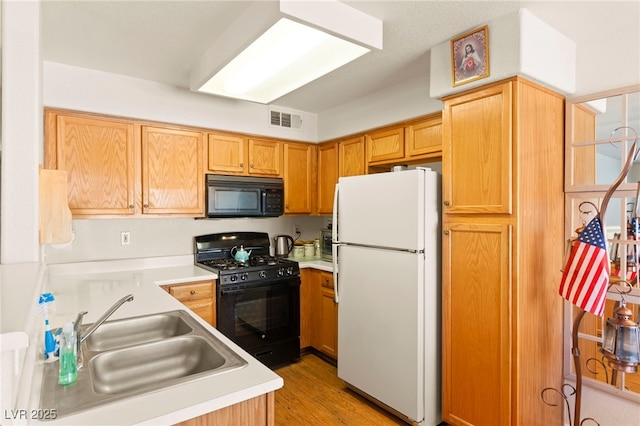 3152 Tarpon Dr Unit 203, Las Vegas, NV 89120 - kitchen featuring black appliances, light countertops, and light wood-type flooring