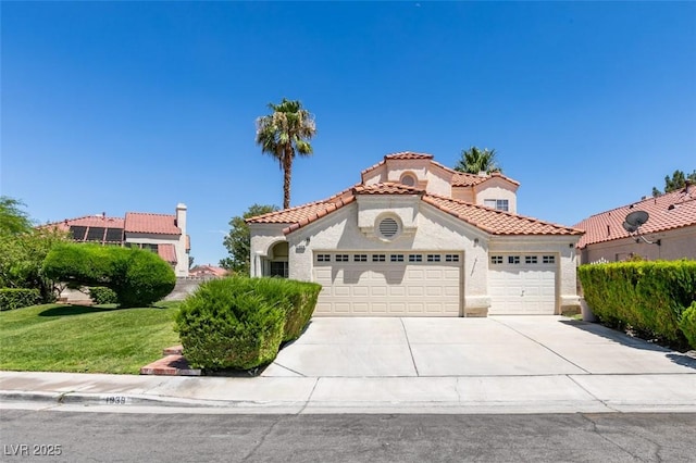 1939 Guinn Dr, Henderson, NV 89074 - mediterranean / spanish home featuring a garage, driveway, stucco siding, a tile roof, and a front yard