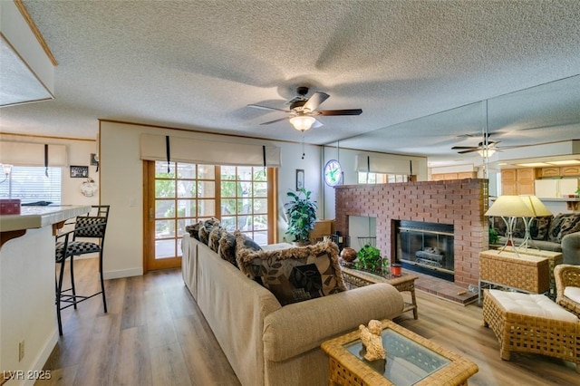 1939 Guinn Dr, Henderson, NV 89074 - living area with a ceiling fan, light wood-style floors, a fireplace, and a textured ceiling