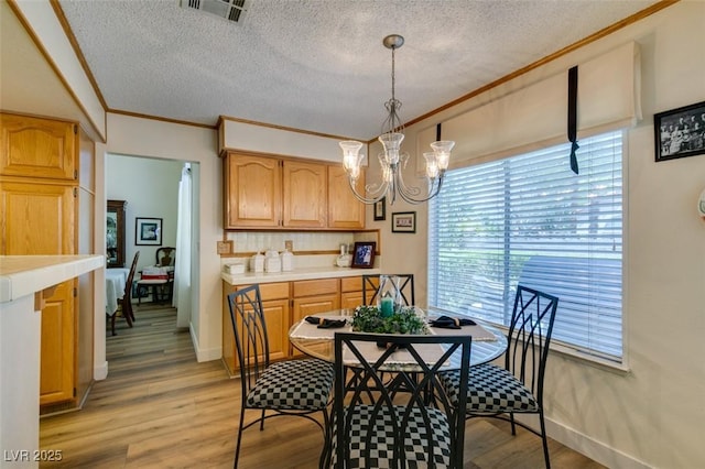 1939 Guinn Dr, Henderson, NV 89074 - dining space featuring a chandelier, ornamental molding, a textured ceiling, and light wood finished floors