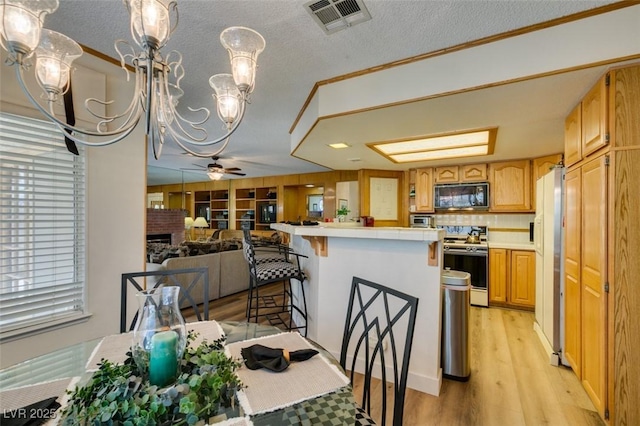 1939 Guinn Dr, Henderson, NV 89074 - dining space with a chandelier, light wood finished floors, ornamental molding, ceiling fan, and a textured ceiling