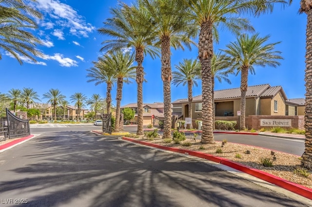 6868 Sky Pointe Dr Unit 1132, Las Vegas, NV 89131 - view of asphalt road featuring curbs, a gated entry, and a residential view