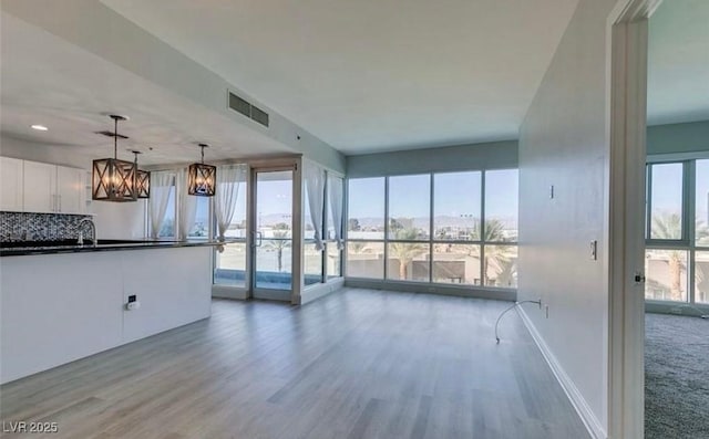 4575 Dean Martin Dr Unit 406, Las Vegas, NV 89103 - unfurnished living room featuring light wood finished floors, a chandelier, and recessed lighting