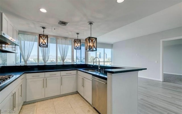 4575 Dean Martin Dr Unit 406, Las Vegas, NV 89103 - kitchen with stainless steel appliances, decorative light fixtures, recessed lighting, dark countertops, and white cabinets