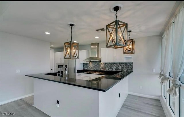 4575 Dean Martin Dr Unit 406, Las Vegas, NV 89103 - kitchen featuring wall chimney range hood, dark countertops, a chandelier, decorative backsplash, and recessed lighting