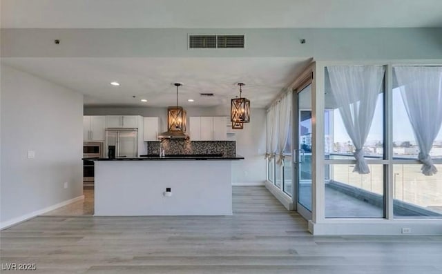 4575 Dean Martin Dr Unit 406, Las Vegas, NV 89103 - kitchen featuring stainless steel appliances, white cabinetry, light wood-style floors, dark countertops, and recessed lighting