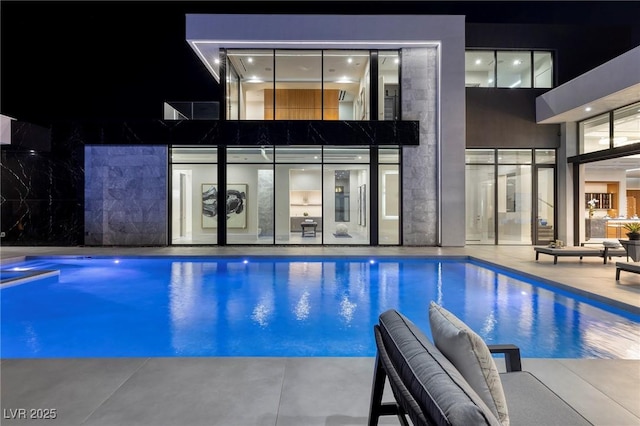 10891 Stardust Dr, Las Vegas, NV 89135 - pool at night featuring an outdoor pool and a patio area