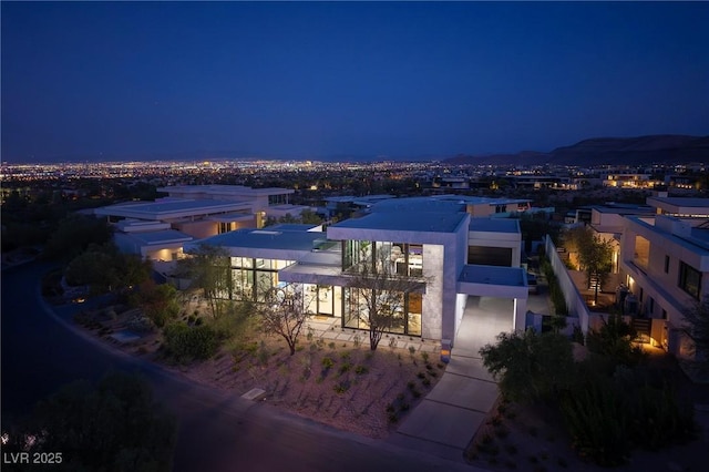 10891 Stardust Dr, Las Vegas, NV 89135 - back of house at night with a balcony and stucco siding
