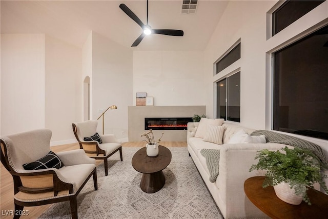 4065 Genoa Dr, Las Vegas, NV 89141 - living area featuring wood finished floors, ceiling fan, a glass covered fireplace, and lofted ceiling