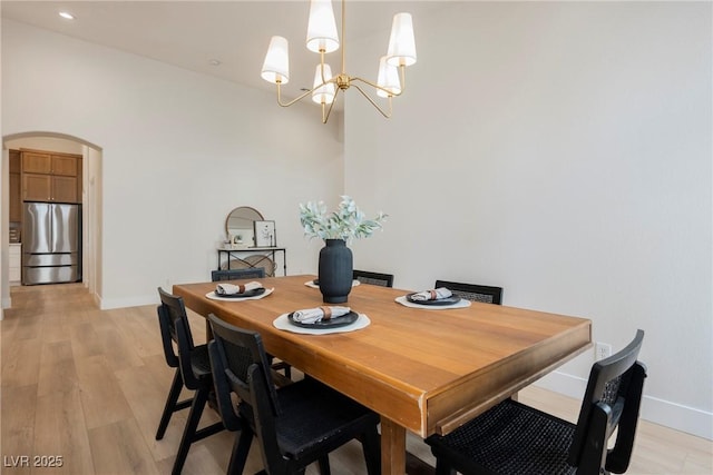 4065 Genoa Dr, Las Vegas, NV 89141 - dining room featuring a chandelier, arched walkways, and light wood-style floors