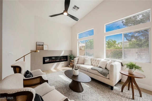 4065 Genoa Dr, Las Vegas, NV 89141 - living room with wood finished floors, high vaulted ceiling, a glass covered fireplace, and a ceiling fan