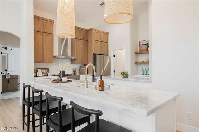 4065 Genoa Dr, Las Vegas, NV 89141 - kitchen with freestanding refrigerator, a breakfast bar, light stone countertops, and open shelves