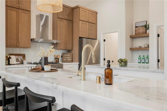4065 Genoa Dr, Las Vegas, NV 89141 - kitchen with wall chimney exhaust hood, open shelves, freestanding refrigerator, a kitchen bar, and light stone countertops