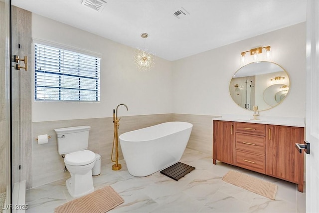 2740 Family Ct, Las Vegas, NV 89117 - bathroom with marble finish flooring, vanity, tile walls, a soaking tub, and a wainscoted wall