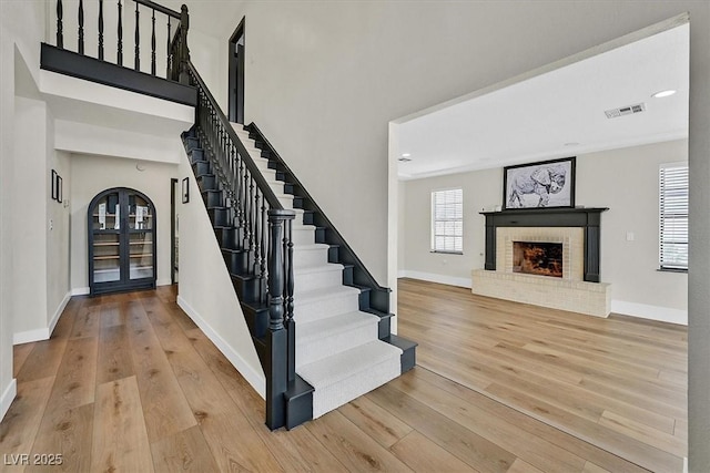2740 Family Ct, Las Vegas, NV 89117 - entryway featuring stairs, hardwood / wood-style flooring, a brick fireplace, and a high ceiling