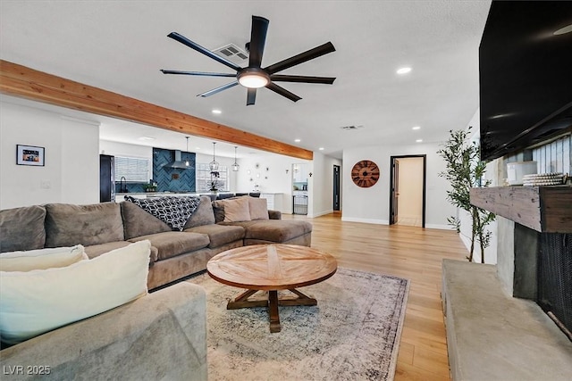 2740 Family Ct, Las Vegas, NV 89117 - living area featuring ceiling fan, recessed lighting, light wood-style floors, beam ceiling, and a fireplace with raised hearth