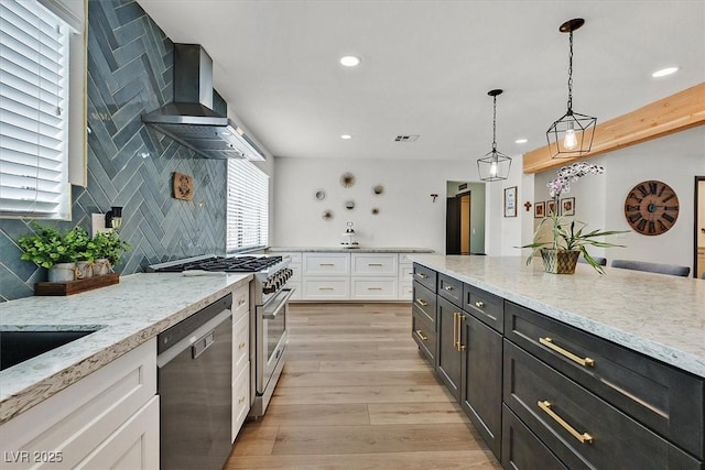 2740 Family Ct, Las Vegas, NV 89117 - kitchen with dishwashing machine, white cabinetry, high end stainless steel range oven, wall chimney exhaust hood, and recessed lighting
