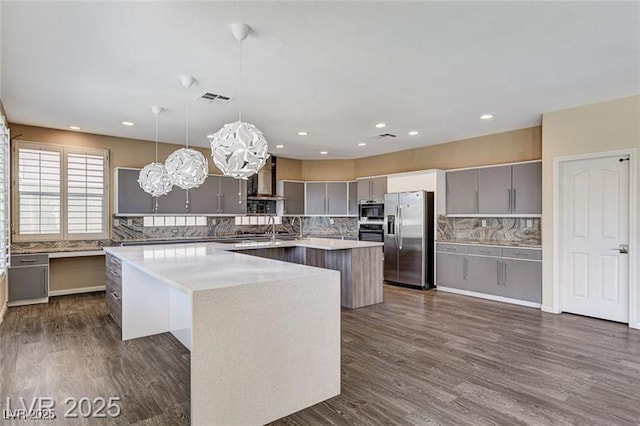 8113 Gothic Ave, Las Vegas, NV 89117 - kitchen with appliances with stainless steel finishes, a center island, gray cabinetry, backsplash, and ventilation hood