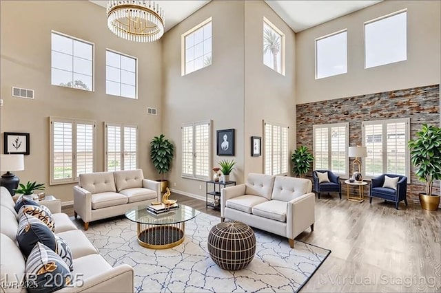 8113 Gothic Ave, Las Vegas, NV 89117 - living area with a towering ceiling, plenty of natural light, wood finished floors, and a chandelier