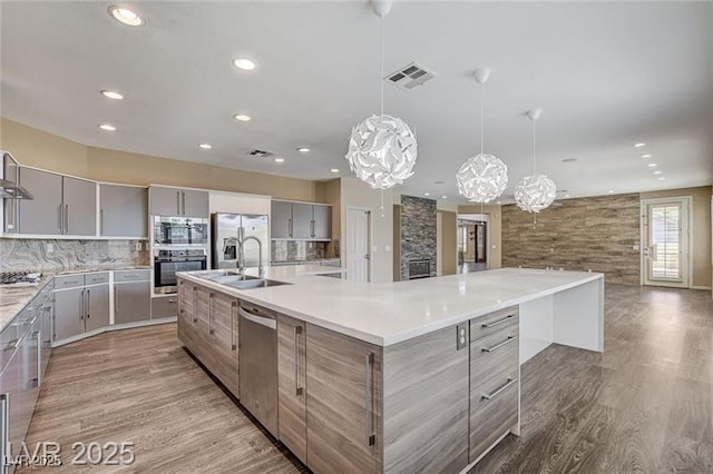 8113 Gothic Ave, Las Vegas, NV 89117 - kitchen featuring gray cabinets, appliances with stainless steel finishes, modern cabinets, recessed lighting, and a large island with sink