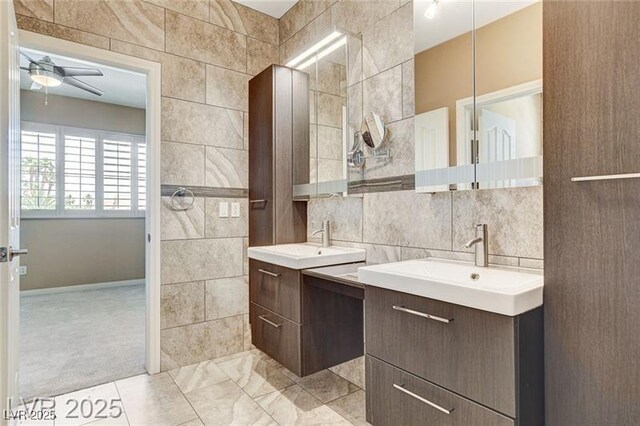 8113 Gothic Ave, Las Vegas, NV 89117 - bathroom with tile walls, ceiling fan, two vanities, and backsplash
