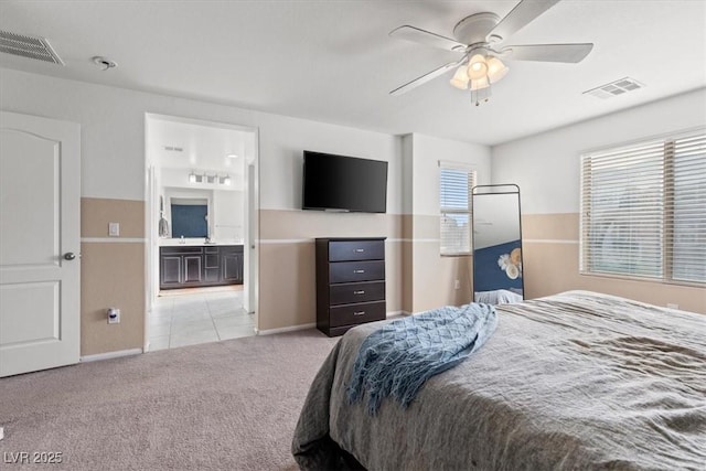 6301 Beavertail Pond Ave, Las Vegas, NV 89122 - bedroom featuring light carpet, connected bathroom, light tile patterned floors, and ceiling fan