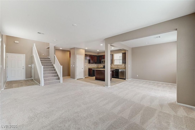 7534 Earnshaw Ave, Las Vegas, NV 89179 - unfurnished living room featuring light carpet, stairway, and recessed lighting