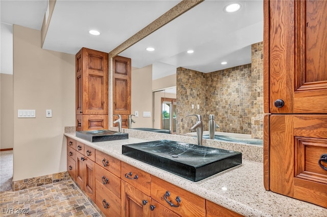 7045 Edna Ave, Las Vegas, NV 89117 - bathroom featuring vanity, recessed lighting, a tub to relax in, and stone finish flooring