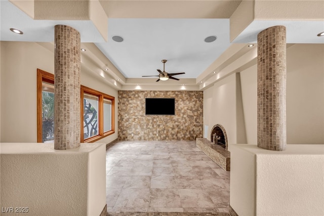 7045 Edna Ave, Las Vegas, NV 89117 - unfurnished living room featuring a ceiling fan, a raised ceiling, recessed lighting, and ornate columns