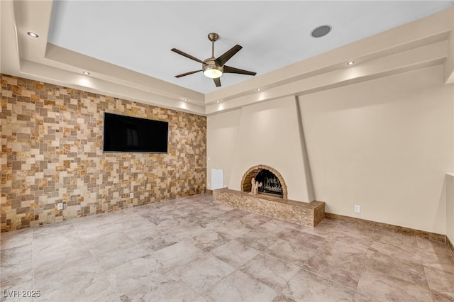 7045 Edna Ave, Las Vegas, NV 89117 - unfurnished living room with a ceiling fan, a tray ceiling, a large fireplace, and recessed lighting