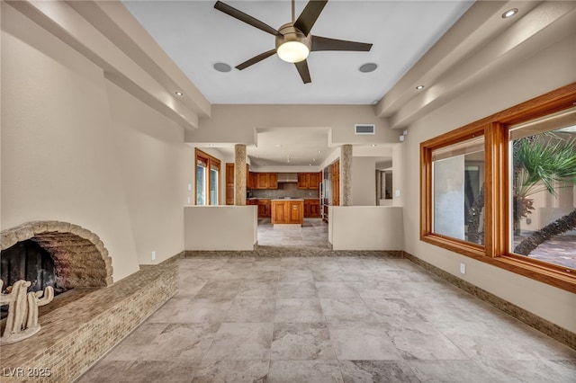 7045 Edna Ave, Las Vegas, NV 89117 - unfurnished living room featuring a ceiling fan, a fireplace, light stone finish flooring, and recessed lighting