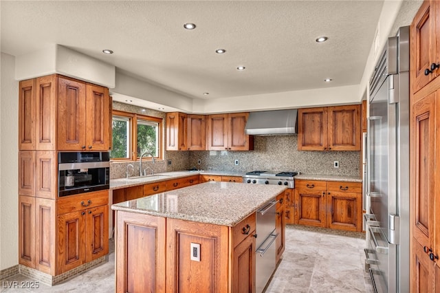7045 Edna Ave, Las Vegas, NV 89117 - kitchen featuring wall chimney exhaust hood, brown cabinets, stainless steel appliances, a textured ceiling, and recessed lighting