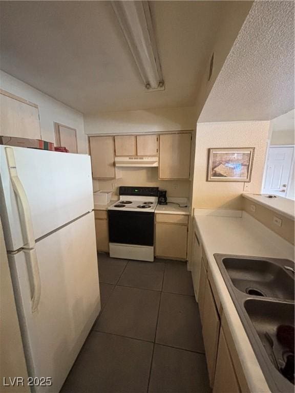8101 W Flamingo Rd Unit 1109, Las Vegas, NV 89147 - kitchen featuring white appliances, under cabinet range hood, light countertops, and dark tile patterned floors