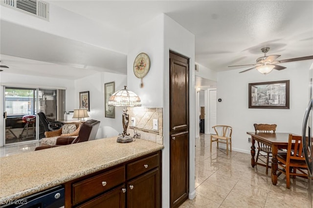 2725 S Nellis Blvd Unit 1037, Las Vegas, NV 89121 - kitchen with ceiling fan, open floor plan, backsplash, dark brown cabinetry, and light stone countertops