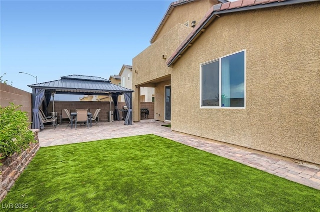 2821 Gaffer Film St, Las Vegas, NV 89156 - rear view of property with stucco siding, a gazebo, a patio, and a fenced backyard