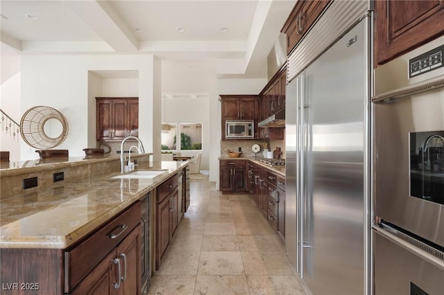 8712 Mesa Canogo Dr, Las Vegas, NV 89148 - kitchen featuring built in appliances, light stone countertops, decorative backsplash, dark brown cabinetry, and recessed lighting